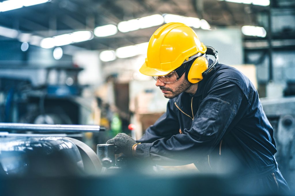 Knights Legal Services - A man wearing a hard hat working on a machine.