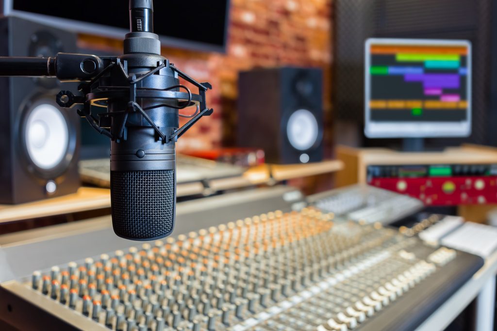 Oasis take legal action over the sale of archive recordings - A microphone in front of a recording desk with speakers.