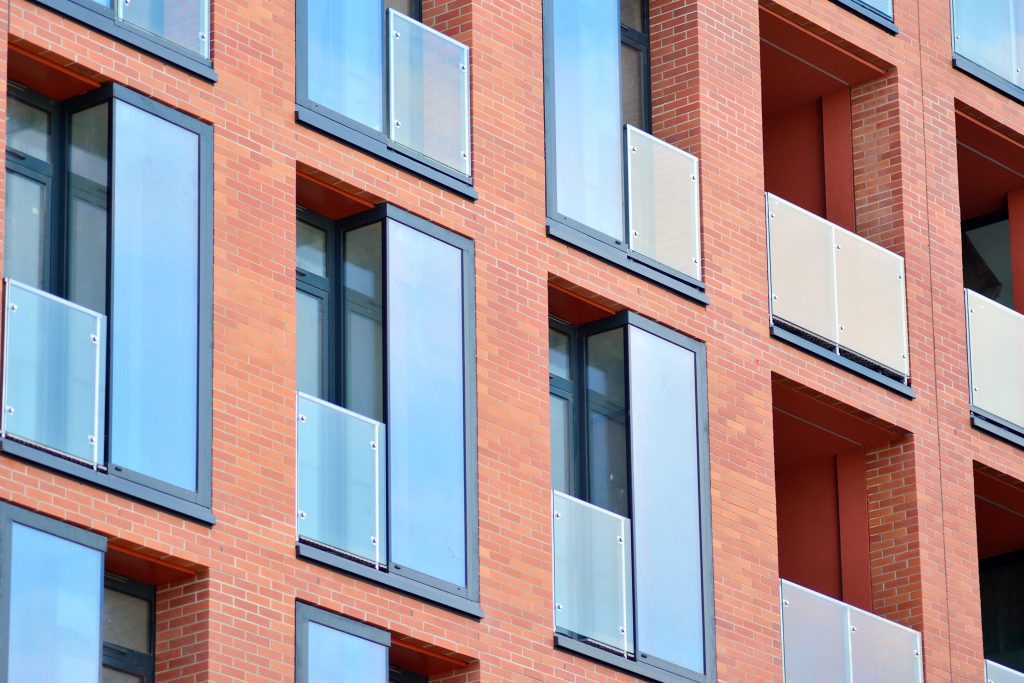 Knights advises Urban Centric on refinancing deal for co-living schemes - A tall brick building with many windows and balconies.